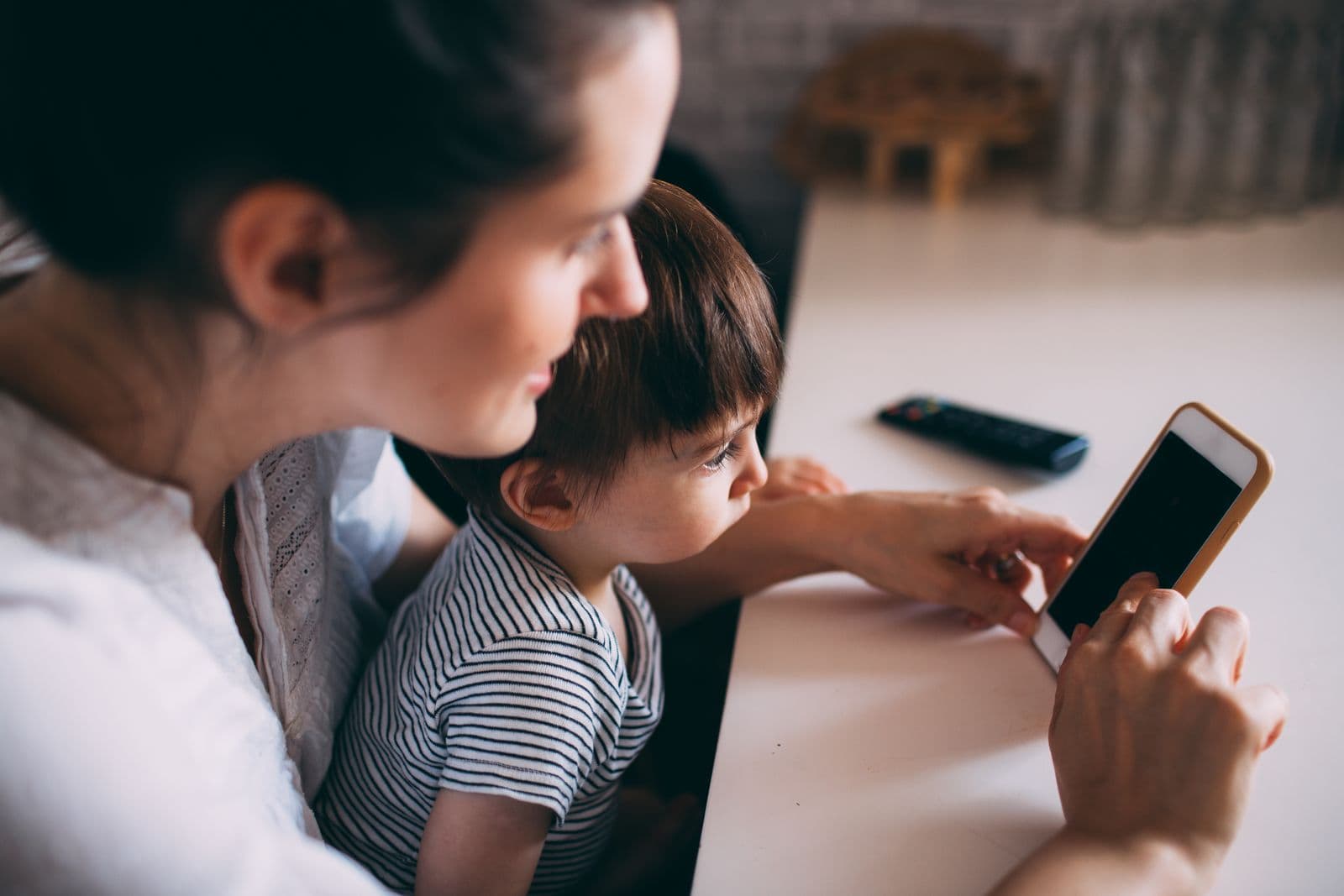 A parent and child looking at a phone together — the real, everyday moment this app's transparency is built around